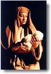 A woman, dressed in Bible attire, holding a baby.