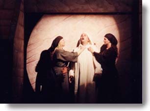 Lazarus comes out of the tomb with Mary and Martha at his side.