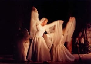 Women, dressed in flowing white outfits, dancing as Angels.