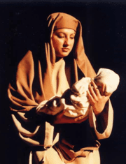 A woman, dressed in Bible attire, holding a baby.