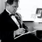 Keith Ward reviewing his music in a tux.